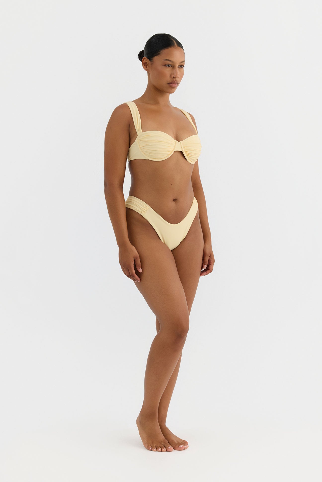 Woman wearing a yellow bikini on a white background