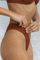 Person wearing a terracotta bikini against a light background