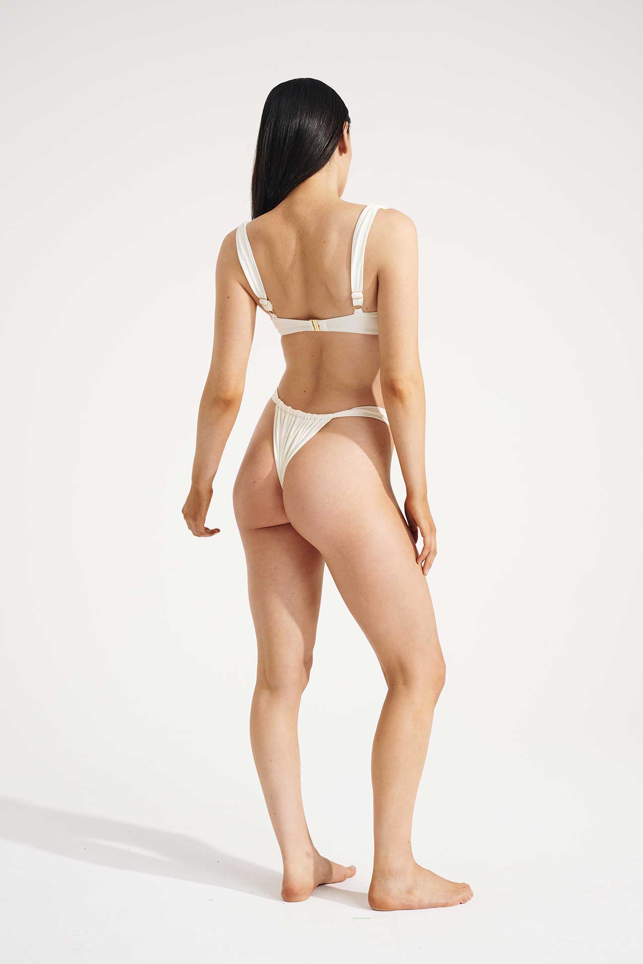 Woman wearing a white bikini on a plain background