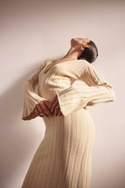 Woman wearing a beige dress against a plain background