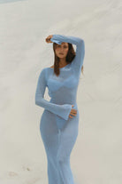 Woman wearing a light blue dress against a white background