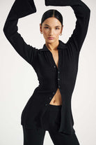 Woman wearing a black ribbed cardigan on a white background