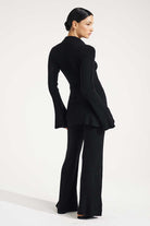 Woman wearing a black suit on a white background