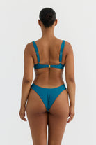 Person wearing a teal bikini on a white background