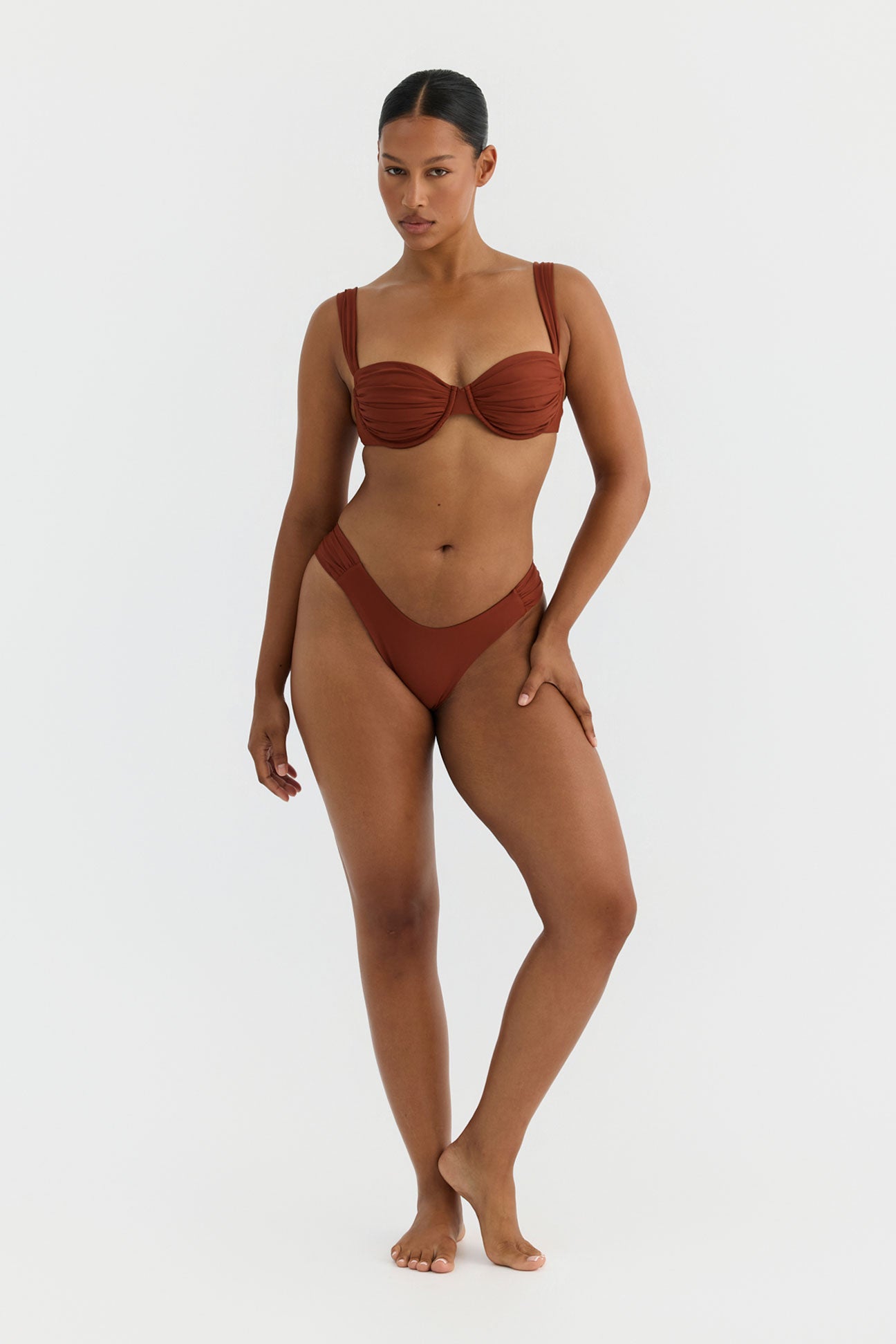 Woman wearing a terracotta swimsuit on a white background