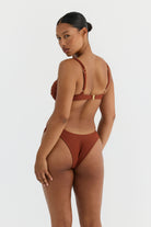 Woman wearing a terracotta bikini set on a white background