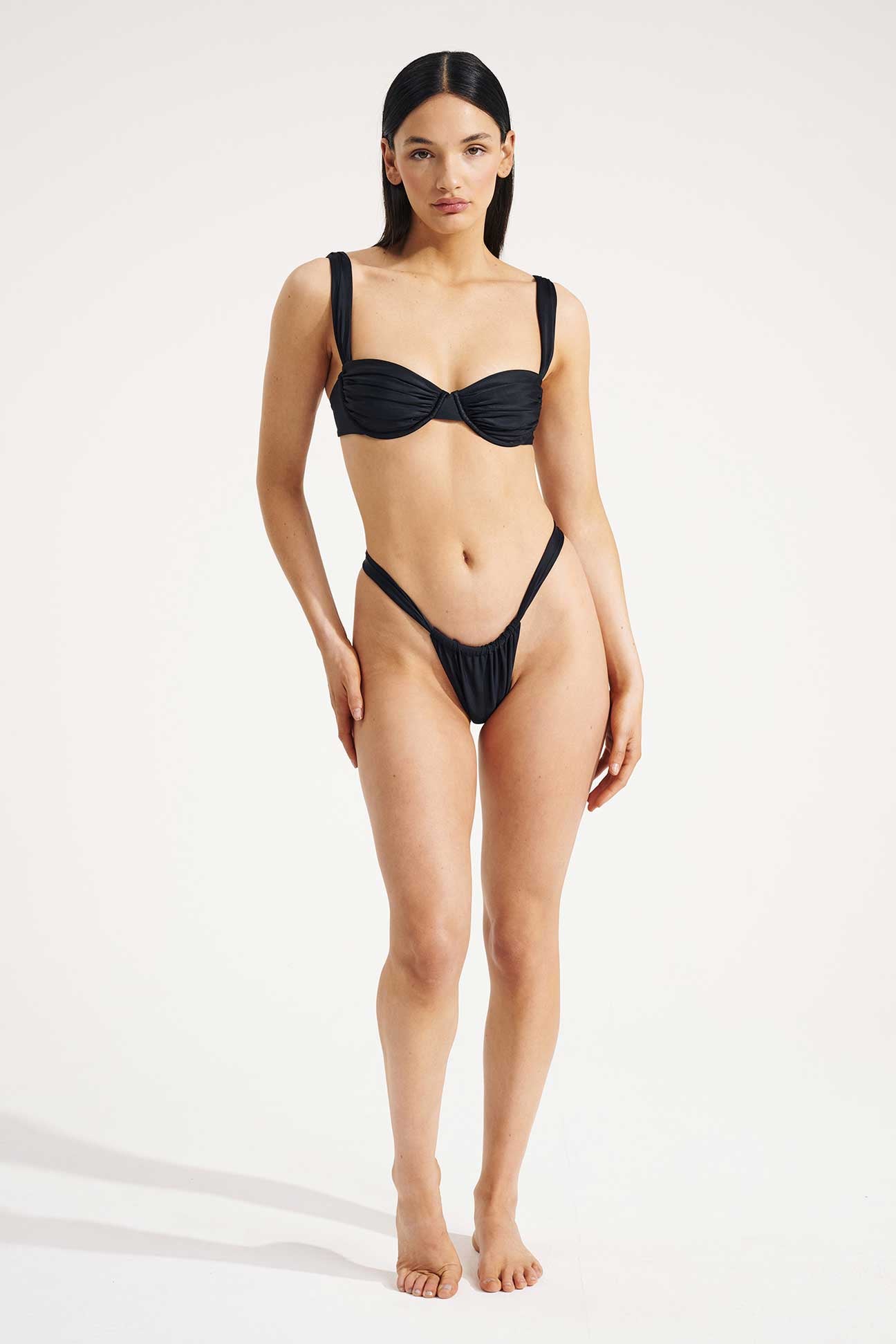 Woman wearing a black bikini on a white background