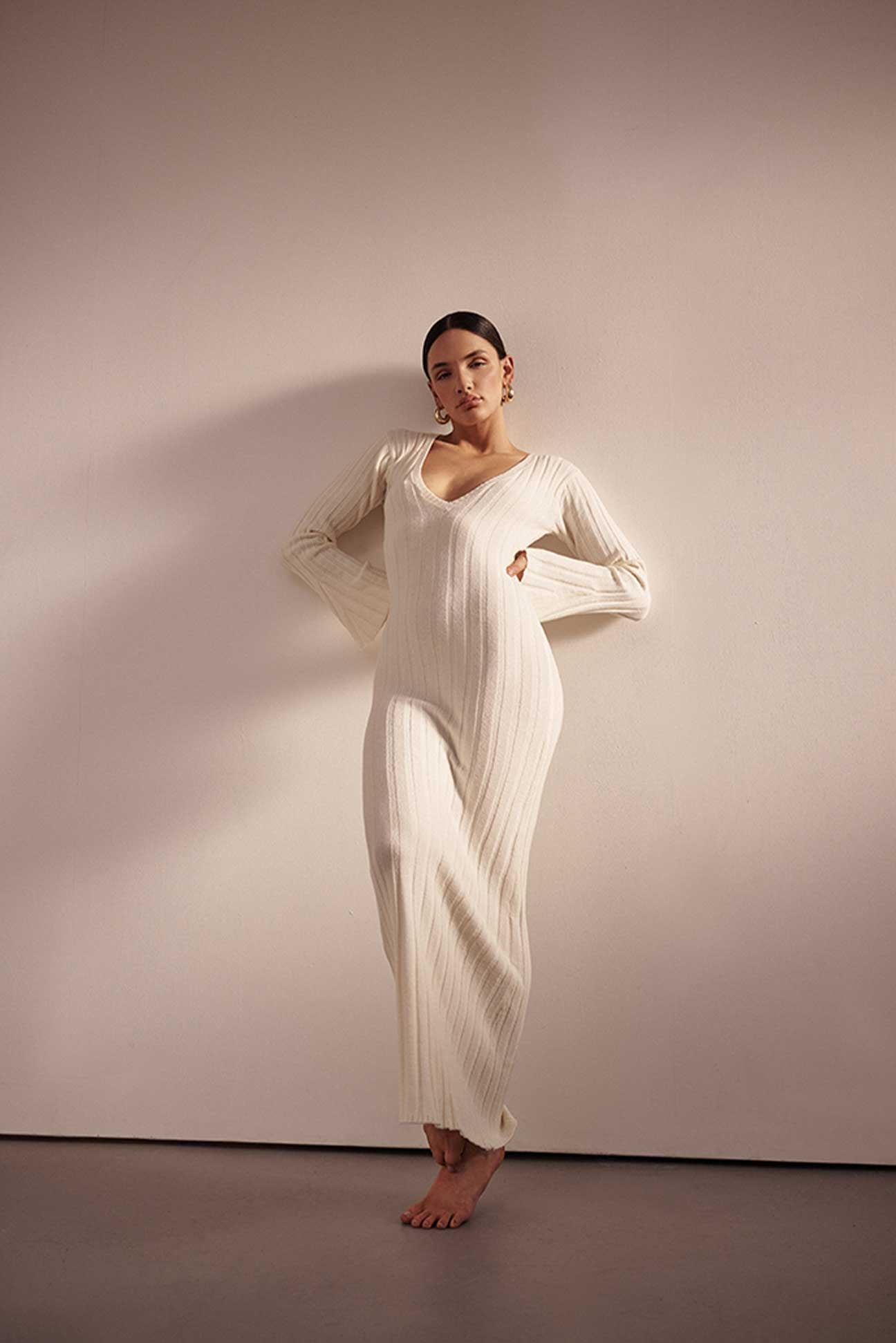 Woman wearing a white dress against a plain background