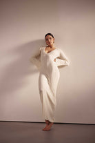 Woman wearing a white dress against a plain background
