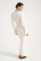 Woman wearing a long, light-colored dress on a white background