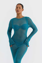 Model wearing a teal sheer dress against a white background