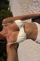 Person wearing a white bikini on a sunlit outdoor path