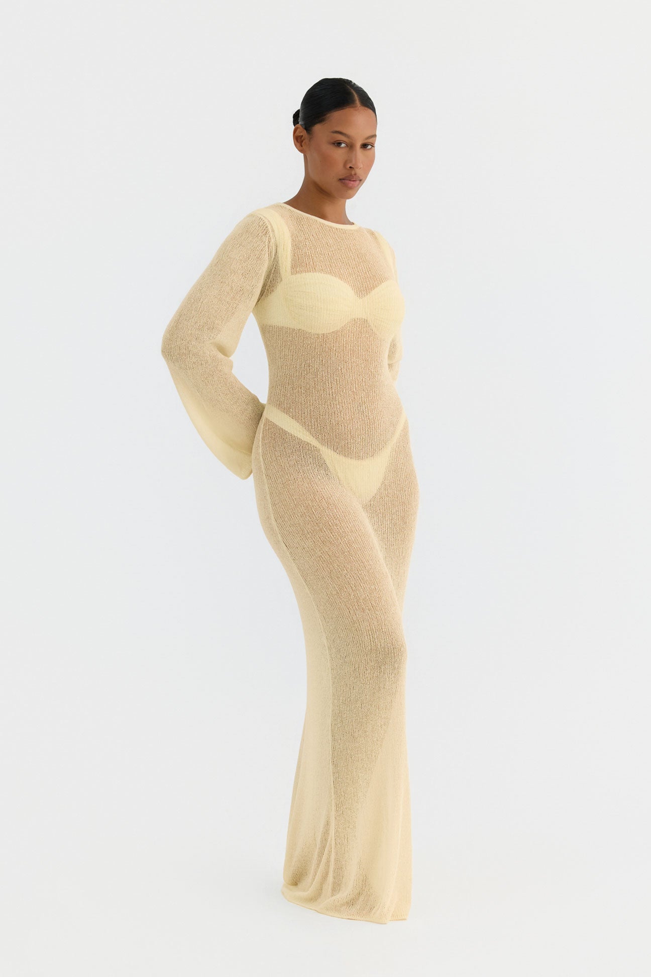 Woman wearing a beige knit dress on a white background