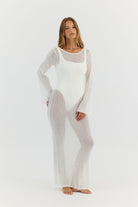 Woman wearing a sheer white outfit on a light gray background