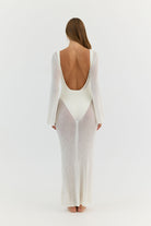 Woman wearing a white long-sleeve gown with a low back on a white background