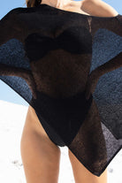Person wearing a black top on a beach.