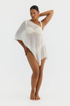 Woman wearing a white cover-up on a plain background