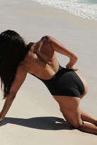 Person in a black swimsuit on a beach