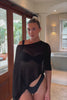 Woman wearing a black shawl top.