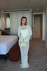 Woman wearing a white dress on a plain background