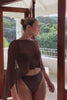 Woman wearing a brown shawl top.