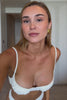Woman wearing a white bikini on a plain background