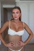 Woman wearing a white bikini against a plain background