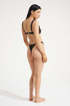 Woman wearing a black bikini on a white background