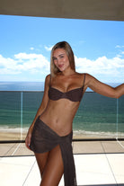 Woman wearing a brown bikini set.