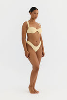 Woman wearing a yellow bikini on a white background