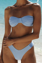 Person wearing a light blue bikini set on a beach.